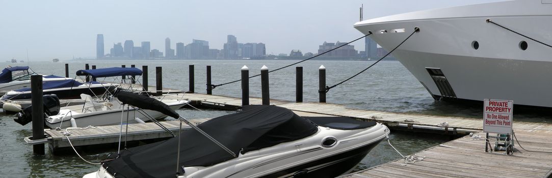 several anchoring boats in Manhattan, New Jersey building silhouettes in distance
