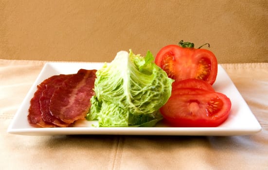 Bacon Lettuce Tomato on a white plate
3 Strips of bacon with crisp lettuce and sliced tomato.