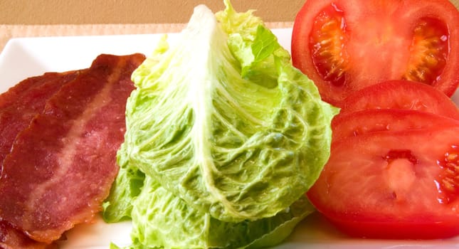 Bacon Lettuce Tomato on a white plate
3 Strips of bacon with crisp lettuce and sliced tomato.