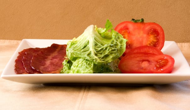 Bacon Lettuce Tomato on a white plate
3 Strips of bacon with crisp lettuce and sliced tomato.