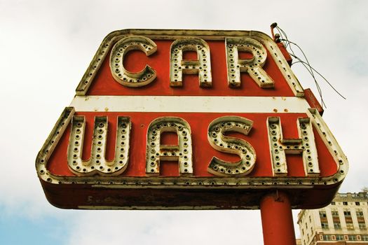 This is an old art deco sign for a car wash that has been torn down for many years. The sign is still there reminding us of the past.