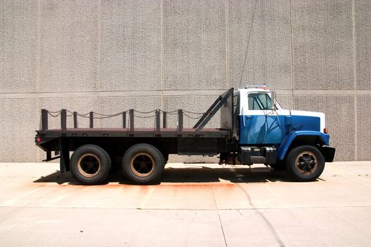 This is the side view of a flat bed stright truck with a city style day cab.