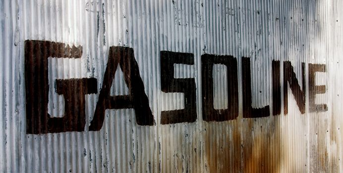 This is a picture of an old sign hand painted on a corrugated steel wall from an old abandoned gas station.