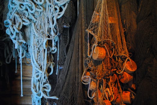 Fishing nets and fishing equipment hanging on wall.