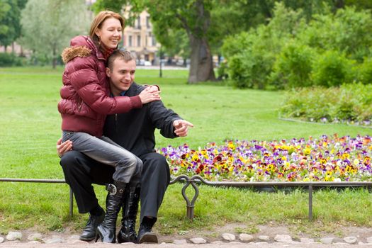 Laughing young couple interested in something in park