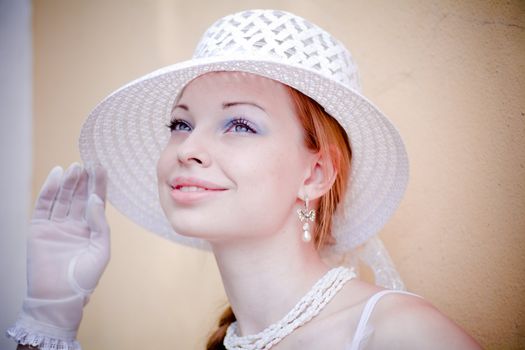 Young lady wearing white hat looking up dreaming