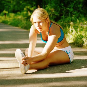 Young woman working out on a forest path.