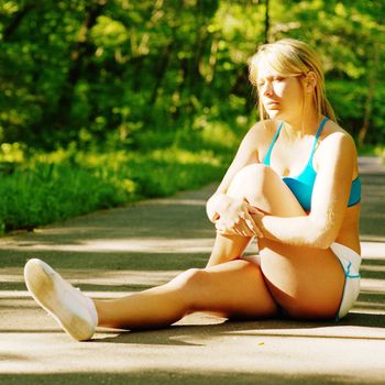 Young woman working out on a forest path.