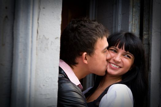 Happy young kissing couple portrait in doors