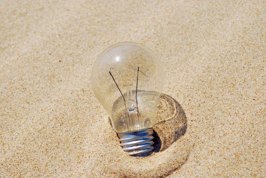 concept of a lightbulb on sand (environment issue)