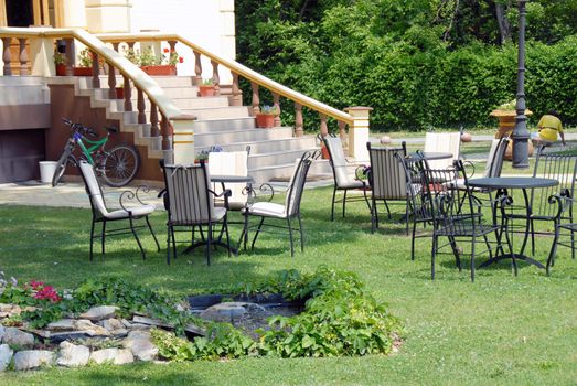 house stairs  with flowerpots and tables on lawn in yard