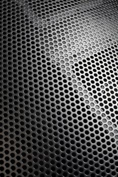 Photo of a loudspeaker grill as a background.  Selective focus through the middle.
