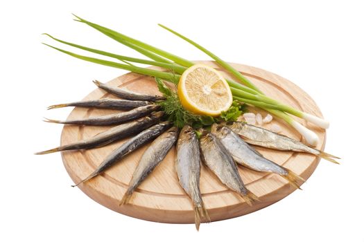 A composition with clupea herring fish (Clupea harengus membras) on wooden plate isolated on white