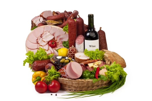 A composition of meat and vegetables with a bottle of wine isolated on white. File includes clipping path for easy background removing.
