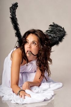 Brunette girl is posing and playing an angel