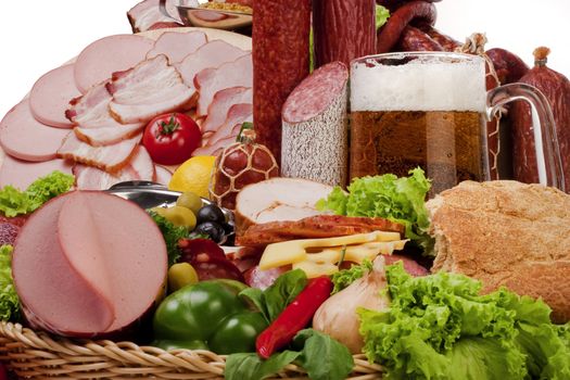 A composition of meat and vegetables with a pot full of beer isolated on white