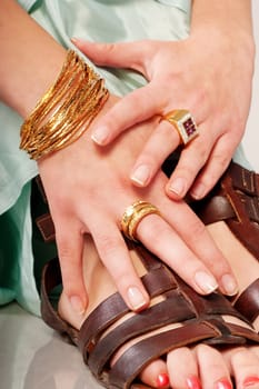Hand with jewellery holds on feet