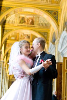 Bride and groom dancing indoors looking to each other