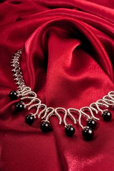 Black pearl necklace on red textile