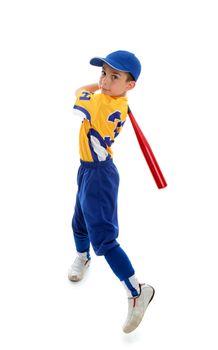 A young child wearing a baseball or softball uniform swinging a bat on a white background.