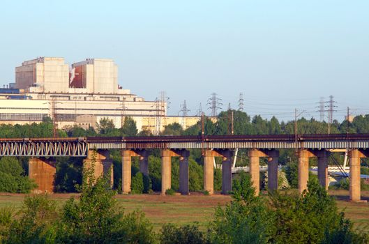 Railway estacade with the power plant in background, high voltage lines