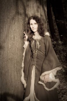 Lady in medieval dress in the forest
