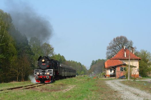 Steam passenger train starting from the small station