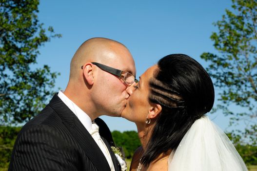 Bride and groom is kissing each other.