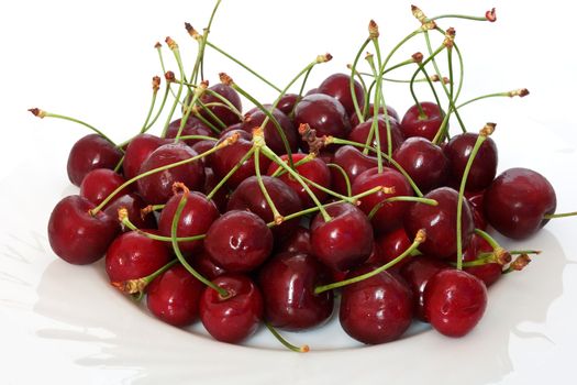 a group of ripe cherries on o white plate