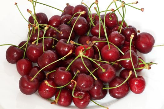 a group of ripe cherries on o white plate