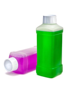Two transparent plastic bottles with color cleaning liquid. One standing and one lying.