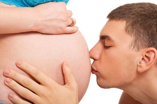 Man kissing pregnant woman in a belly. Studio shoot on white.