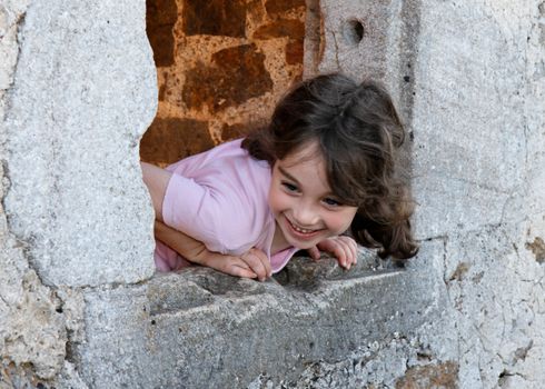 Smiling girl leans out of the castle window