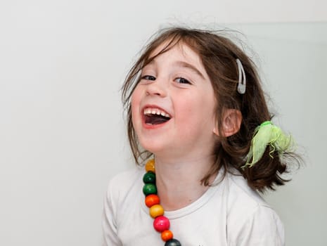 Laughing girl in white shirt with colored beads