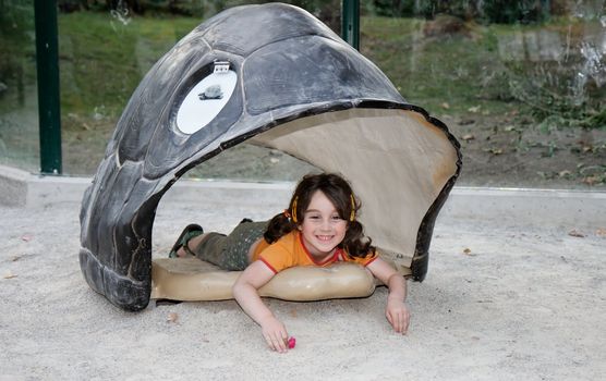 Cute little girl lies in the turtle shell