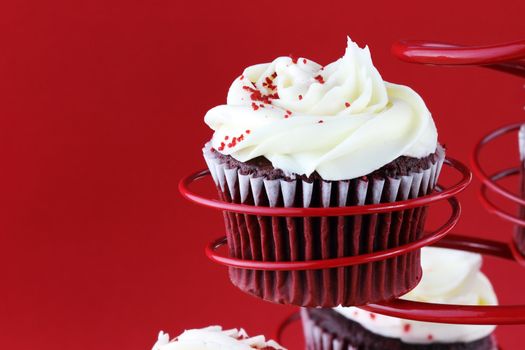 Red velvet cupcake in a red cupcake holder against a red background with copy space included.