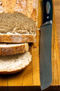 White bread and knife on wooden cutting board