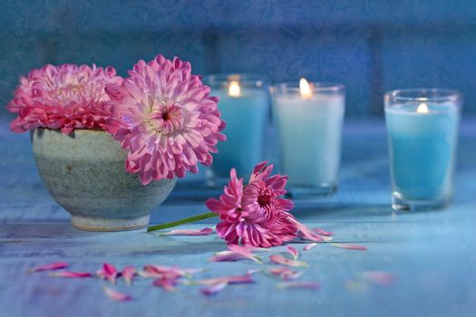 Chrysanthemum flowers in bowl of water with candles