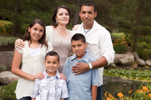 Happy Hispanic Family Portrait In the Park.