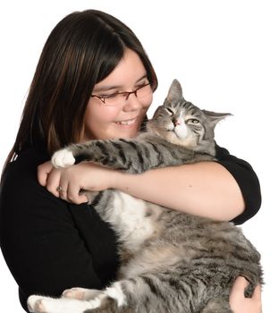 A young teen girl is loving and holding her pet cat, isolated against a white background.