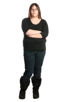 A stubborn teenager is standing with her arms crossed, isolated against a white background.