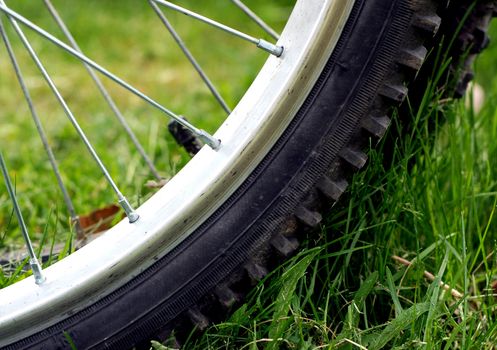 Close up view of a parked bicycle tire on green grass