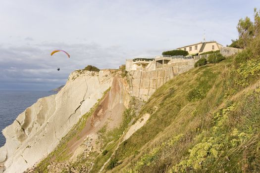 a house in front of the sea and a parachute