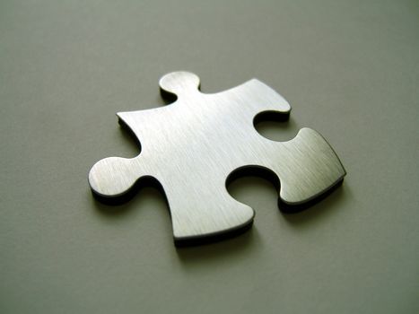 Chrome jigsaw piece on metallic background