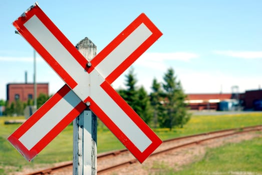 Old railroad crossing stop sign in a rural scene with shallow focus