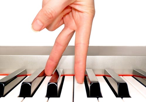 Feminine hand fingers walking along a piano keyboard