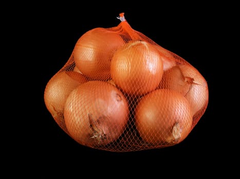 Onions in an orange mesh bag against a black background.