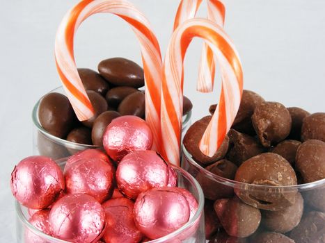 Chocolate covered almonds and peanuts, foil wrapped chocolate, and candy canes.