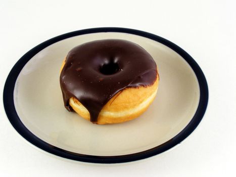 A chocolate iced donut on a plate against a white background.