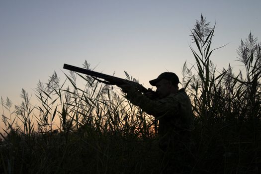 Silhouette of the hunter on a background of a morning dawn